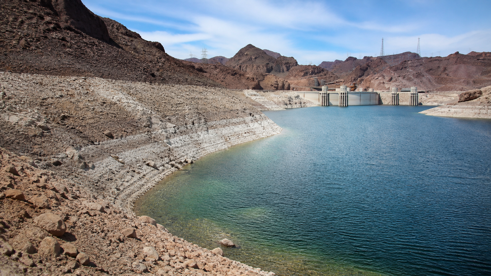 Lake Mead shoreline and Hoover Dam under a clear desert sky